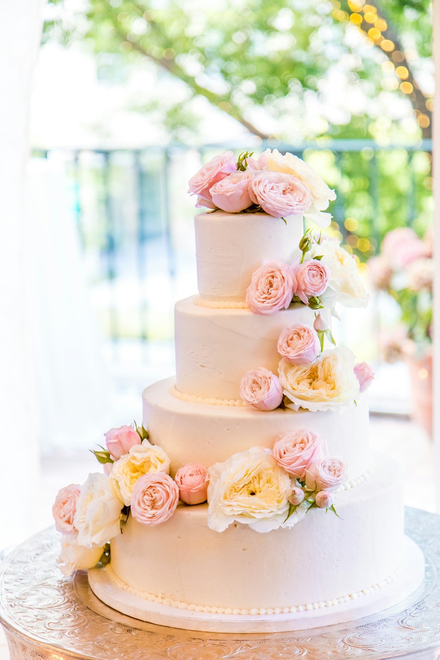 Luxury pink ombre tiered cake with fresh roses on a gold cake stand